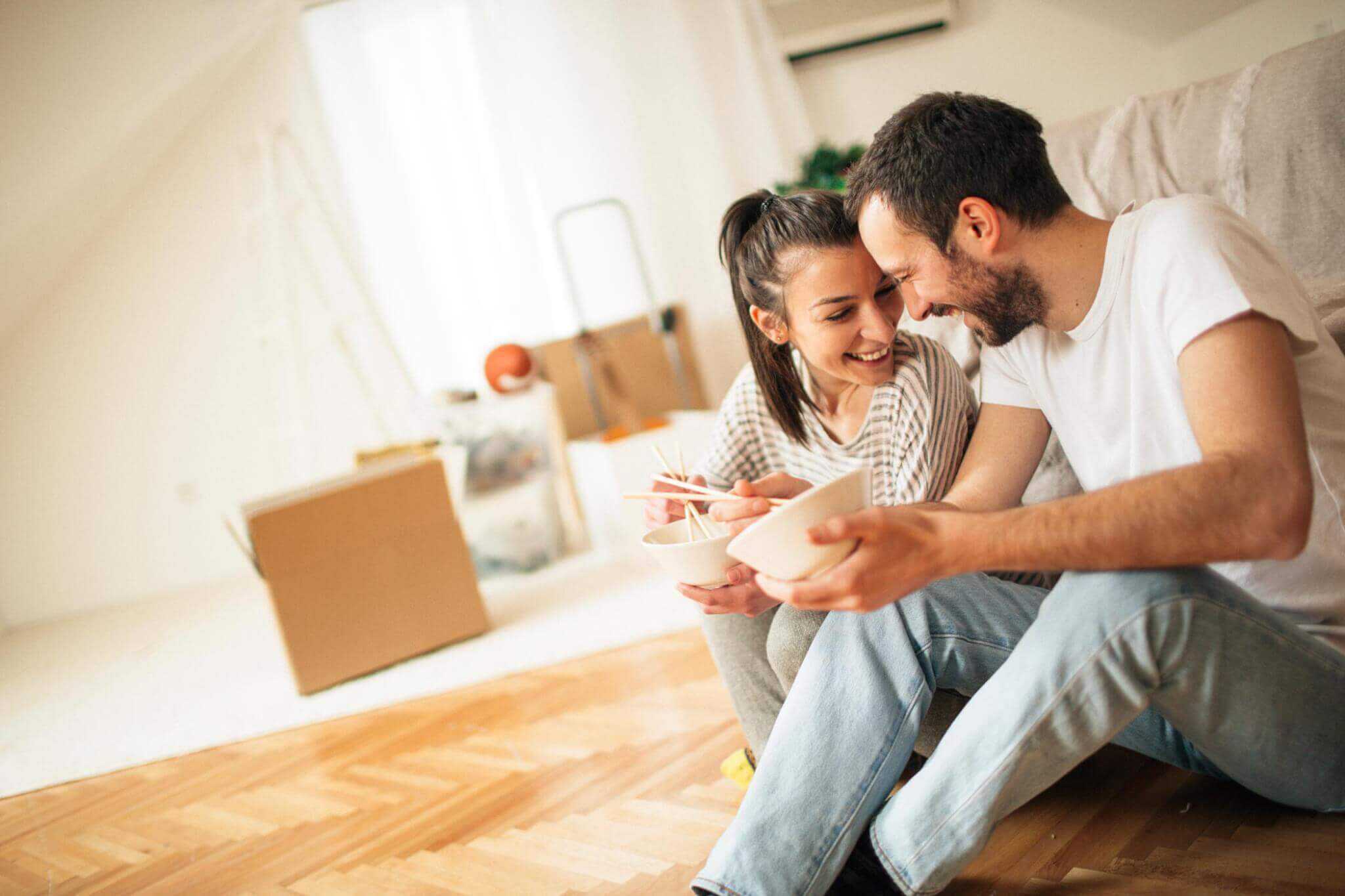 trabalhadores independentes felizes numa casa vazia após conseguirem o crédito habitação para a sua nova casa